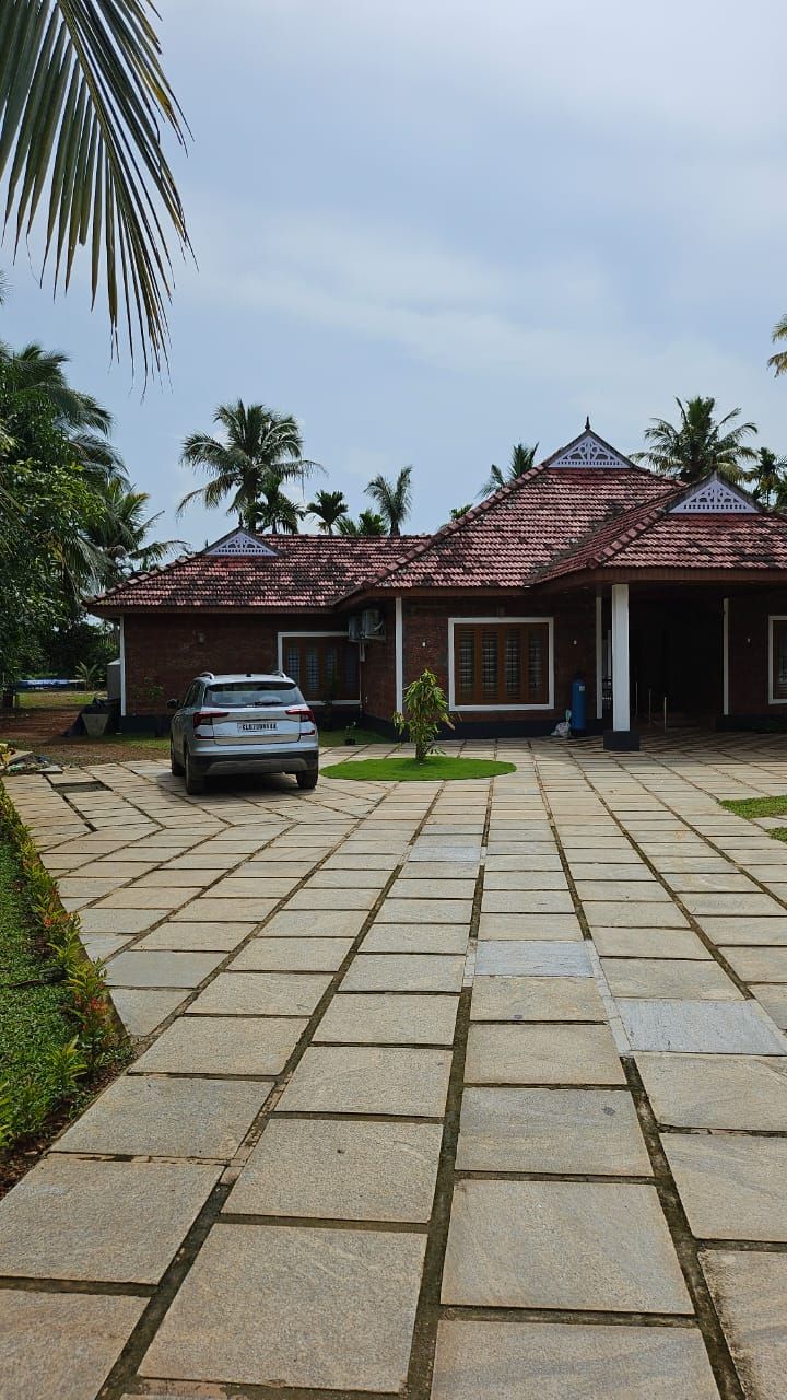 Main house with red tiled roof and paved driveway